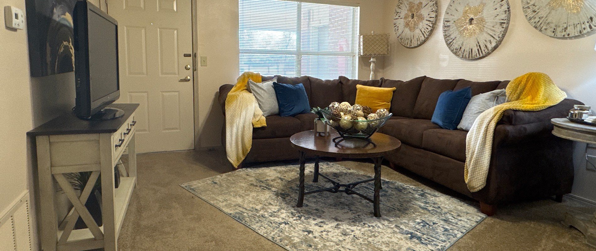 A living room with a brown couch and a coffee table.